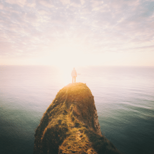 Man on top of cliff being mindful of his surroundings