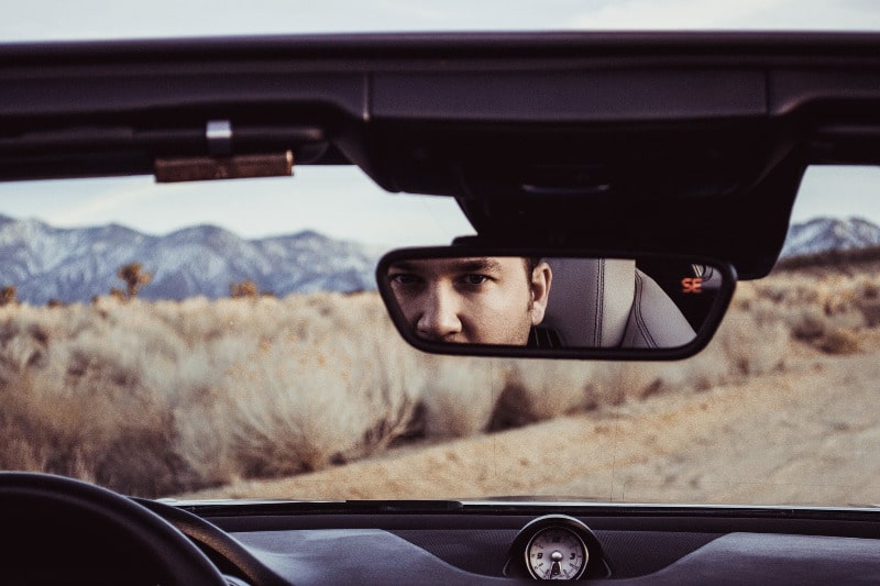 Man looking in the rear view mirror