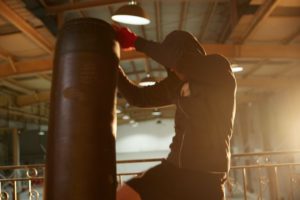 man kicking punching bag