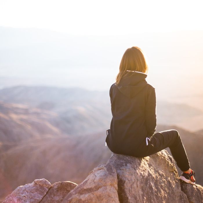 woman sitting on top of a mountain