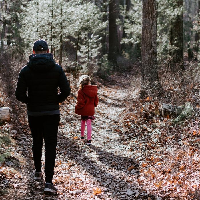 father and daughter walking in the woods